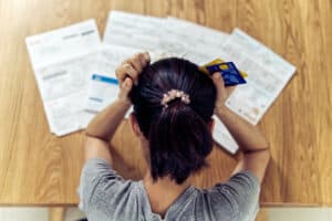 SGP Credit - Personal Loan With Low Interest Rate | top-view-stressed-young-sitting-asian-woman-hands-holding-head-worry-about-find-money-pay-credit-card-debt-all-loan-bills