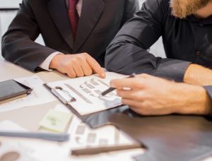 SGP Credit - Personal Loan With Low Interest Rate | close-up-two-businessmen-pointing-business-chart-meeting