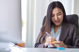 SGP Credit - Personal Loan With Low Interest Rate | Businesswoman takes notes on a sticky note