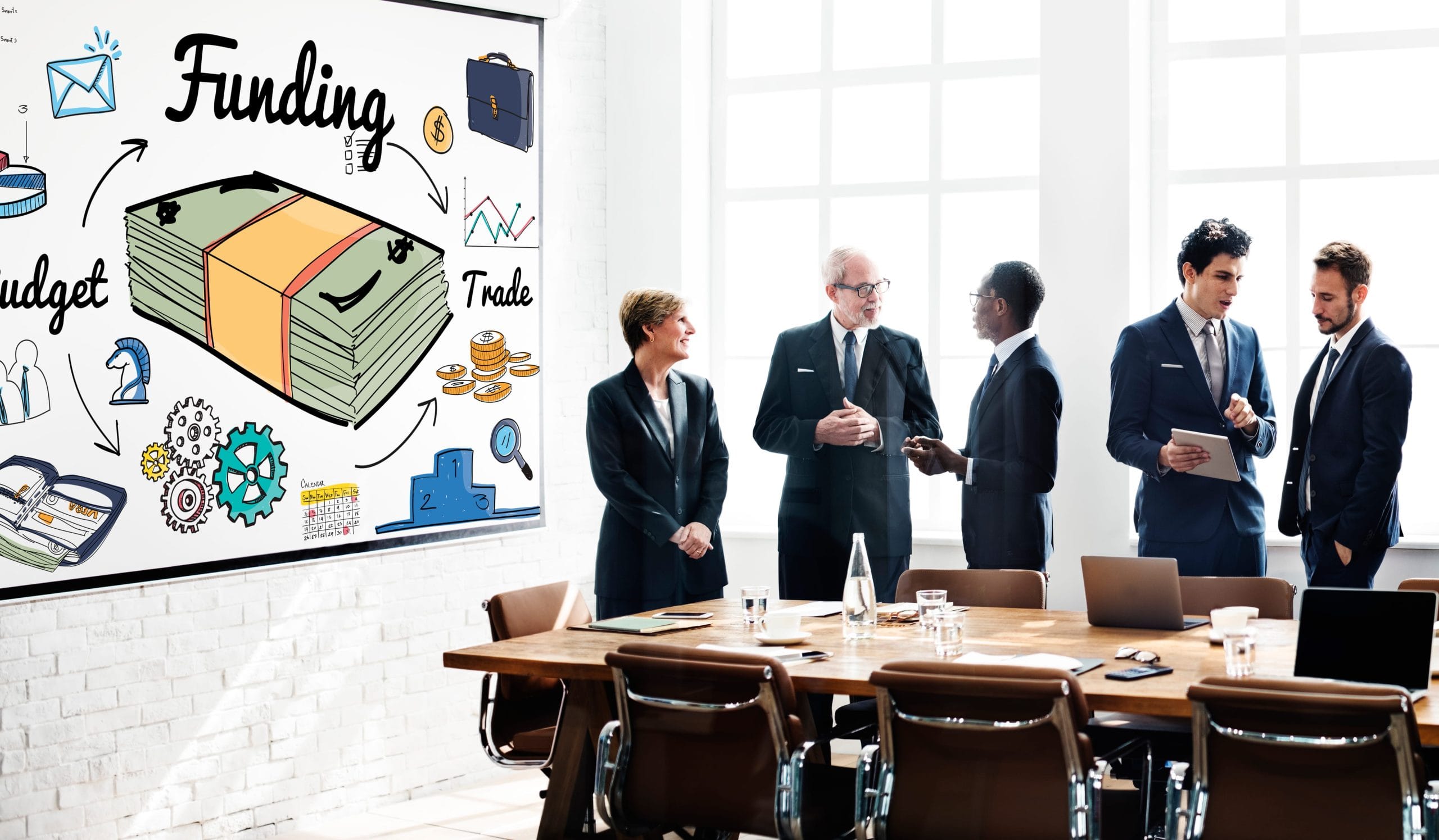 funding-banking-budget-credit-financial-concept 1 | SGP Credit - Personal Loan With Low Interest Rate | SGP Credit - Personal Loan With Low Interest Rate Group of professionals in business attire discussing funding ideas beside a whiteboard filled with money illustrations and charts in a bright conference room.